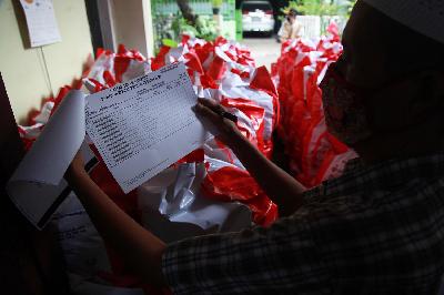 Petugas rukun warga memeriksa data penerima bantuan sosial dari Presiden RI untuk warga berdampak Covid-19 di Pasar Minggu, Jakarta, 20 Mei 2020. TEMPO/Nita Dian
