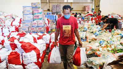 Pekerja membawa paket bantuan sosial (bansos) yang akan disalurkan di Gudang Food Station Cipinang, Jakarta, 22 April 2020. ANTARA/M Risyal Hidayat
