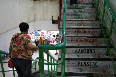 Warga menuruni tangga yang ditulisi kampanye mengurangi penggunaan kantong plastik di Pasar Tebet Barat, Jakarta, 22 Juli 2020. TEMPO/Muhammad Hidayat