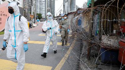 Petugas kesehatan dengan mengenakan alat pelindung diri (APD) mendisinfeksi area yang ditutup karena menjadi kluster Covid-19, di Kuala Lumpur, Malaysia 29 Juni 2021. REUTERS/Lim Huey Teng