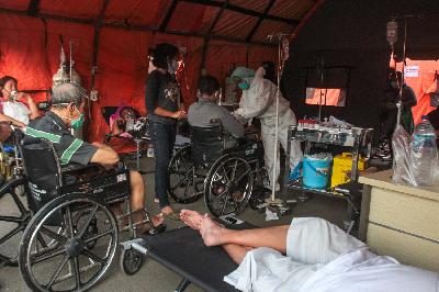 Petugas medis memeriksa pasien di tenda darurat RSUD dr Chasbullah Abdulmajid Kota Bekasi, Jawa Barat, 25 Juni 2021. TEMPO/Hilman Fathurrahman W