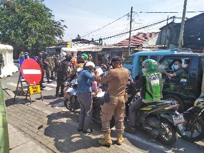 Penyekatan kendaraan bermotor pada Pemberlakuan Pembatasan Kegiatan Masyarakat Darurat di perbatasan Depok, Jalan Raya Bogor, Jakarta, 8 Juli 2021. Tempo/Suseno
