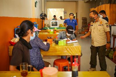 Petugas gabungan Kepolisian, TNI dan Satpol PP melakukan razia pengunjung warung makan yang melanggar aturan Pemberlakuan Pembatasan Kegiatan Masyarakat darurat di Bekasi, 8 Juli 2021. Tempo/Hilman Fathurrahman W