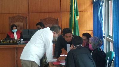Terdakwa Saiful Mahdi (kemeja putih) berkonsultasi dengan penasihat hukumnya usai mendengarkan vonis majelis hakim di Pengadilan Negeri Banda Aceh, Selasa, 21 April 2020/ ANTARA
