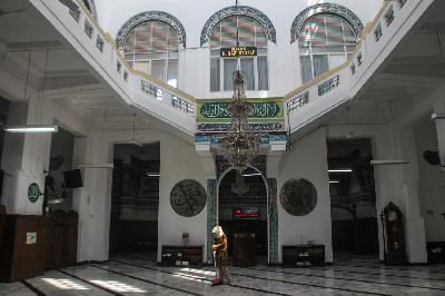 Petugas membersihkan Masjid Cut Meutia saat peniadaan pelaksaan salat Jumat terkait pemberlakuan pembatasan kegiatan masyarakat (PPKM) di Cikini, Jakarta, 25 Juni 2021. TEMPO/Hilman Fathurrahman W