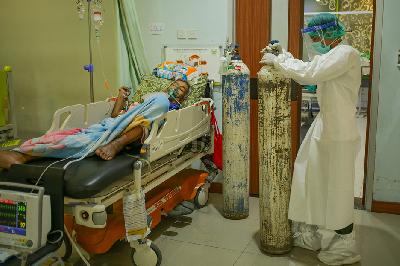 Tenaga medis membawa tabung oksigen untuk digunakan sebagai alat bantu pernapasan bagi pasien Covid-19 di ruang ICU, Rumah Sakit Umum Daerah (RSUD) Tipe D Kramat Jati, Jakarta, 8 Juli 2021. TEMPO / Hilman Fathurrahman W