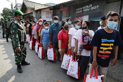 Warga menerima bantuan dari Presiden saat PPKM Darurat di Jakarta, 16 Juli 2021. REUTERS/Willy Kurniawan
