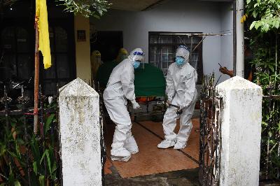 Petugas Dinas Kesehatan Kota Bandung membawa jenazah pasien Covid-19 yang meninggal saat isolasi mandiri di kediamannya di Muararajeun Lama, Bandung, Jawa Barat, 23 Juni 2021. TEMPO/Prima Mulia