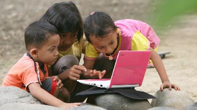Anak-anak sedang belajar melalui media elektronik laptop.
