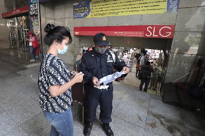Petugas keamanan memeriksa surat vaksin  pengunjung saat akan masuk Blok A Pasar Tanah Abang, Jakarta, 26 Juli 2021. TEMPO/Muhammad Hidayat
