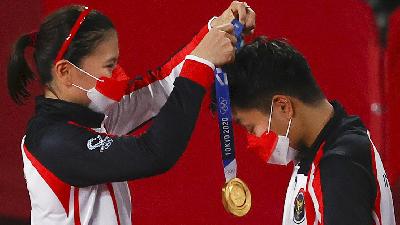 Greysia Polii mengalungkan medali emas kepada Apriyani Rahayu saat menjuarai cabang bulutangkis nomor ganda putri pada Olimpiade Tokyo 2020 di Musashino Forest Sport Plaza, Tokyo, Jepang, 2 Agustus 2021. REUTERS/Hamad I Mohammed