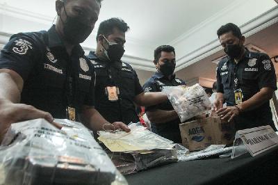 Petugas Kepolisian menata barang bukti saat dihadirkan dalam rilis kasus pengungkapan praktik klinik ilegal yang berada di Ciracas, di Polda Metro Jaya, 23 Februari 2021. Tempo/Hilman Fathurrahman W