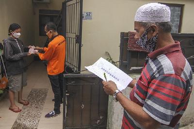 Juru Bayar Kantor Pos Indonesia (kanan) menyalurkan Bantuan Sosial Tunai Kemensos kepada warga di wilayah Bojong Pondok Terong, Depok, 22 Juli 2021. ANTARA/Asprilla Dwi Adha