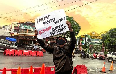 Pemuda membentangkan poster bertuliskan "Rakyat Bantu Rakyat, Pejabat Bantu Penjahat" di Perempatan Pesantren Cipasung, Kabupaten Tasikmalaya, Dok Gerakan Rakyat Menggugat