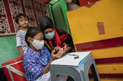 Siswi kelas 2 SDN 01 Pagi Bukit Duri mengikuti belajar daring dengan bimbingan ibunya di sela-sela berjualan makanan di  Bukit Duri, Jakarta, 30 Juli 2020. TEMPO/M Taufan Rengganis