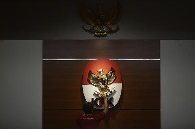 Petugas kebersihan membersihkan logo KPK di gedung Komisi Pemberantasan Korupsi, Jakarta, 10 Mei 2021. TEMPO/Imam Sukamto