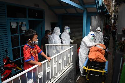 Petugas kesehatan mengevakuasi jenazah yang terpapar Covid-19 saat isolasi mandiri di Bandung, J5 Agustus 2021. TEMPO/Prima Mulia