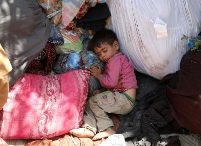 Seorang anak pengungsi internal dari provinsi utara yang melarikan diri dari rumahnya karena pertempuran antara Taliban dan pasukan keamanan Afghanistan tidur di taman umum yang mereka gunakan sebagai tempat berlindung di Kabul, Afghanistan, 10 Agustus 2021. REUTERS/Stringer