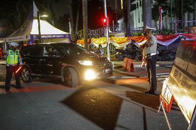 Petugas kepolisian melarang pengendara mobil berplat nomor genap memasuki Jalan MH Thamrin di Bundaran Monas, Jakarta, 13 Agustus 2021. Tempo/Hilman Fathurrahman W