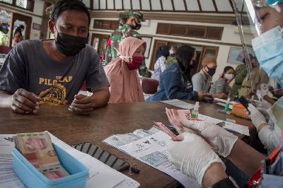 Petugas PT Pos Indonesia menyalurkan Bantuan Sosial Tunai (BST) kepada Keluarga Penerima Manfaat (KPM) di Kantor Kelurahan Banyuanyar, Solo, Jawa Tengah, 26 Juli 2021. ANTARA/Mohammad Ayudha
