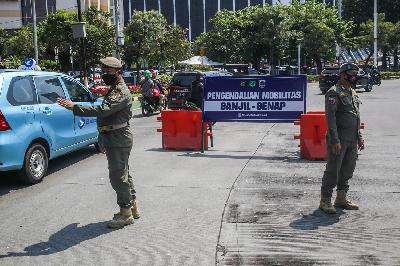 Petugas Satpol PP mengatur lalu lintas pada titik pemeriksaan ganjil-genap Bundaran Senayan di Jakarta, 26 Agustus 2021. TEMPO/Hilman Fathurrahman W