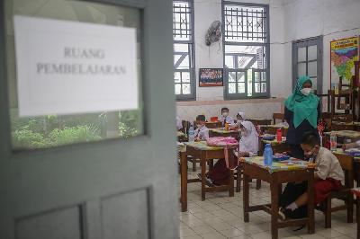 Guru memberikan materi pelajaran kepada murid saat pembelajaran tatap muka pada hari pertama di SD Negeri Manggarai 01, Jakarta, 30 Agustus 2021. Tempo/Hilman Fathurrahman W