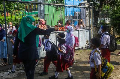 Murid sekolah  dasar meninggalkan sekolah setelah mengikuti pembelajaran tatap muka pada hari pertama di SD Negeri Manggarai 01, Jakarta, 30 Agustus 2021. Tempo/Hilman Fathurrahman W
