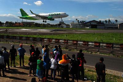 Warga melihat pesawat Citilink saat mendarat di Bandara Husein Sastranegara, Bandung. TEMPO/Prima Mulia