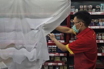 Karyawan memeriksa etalase rokok yang ditutup kain di salah satu minimarket di Jakarta, 14 September 2021. TEMPO/Muhammad Hidayat