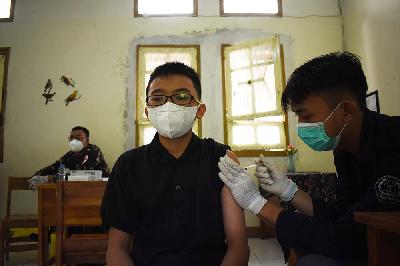 Anak-anak SMP usia 12-15 tahun mendapat suntikan vaksin Covid-19 di ruang kelas SMPN 7 Bandung, Jawa Barat, 21 September 2021. TEMPO/Prima Mulia
