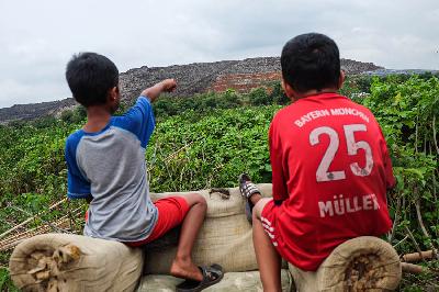 Anak-anak bermain dengan latar gunung sampah di Tempat Pengolahan Sampah Terpadu (TPST) Bantargebang, Bekasi, Jawa Barat, 8 Januari 2021. TEMPO/Hilman Fathurrahman W