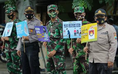 Anggota kepolisian dan TNI melakukan sosialisasi mengimbau masyarakat menggunakan hak suaranya dalam Pilkada Surabaya 2020 di Surabaya, Jawa Timur, 8 Desember 2020. ANTARA/Didik Suhartono