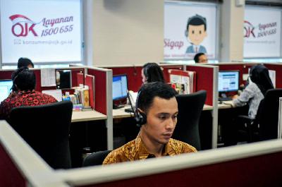 Petugas melayani pengaduan masyarakat melalui telepon di Call Center Otoritas Jasa Keuangan (OJK), Jakarta. TEMPO/Tony Hartawan