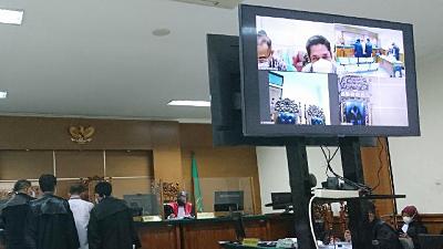 The trial of the corruption of Islamic boarding school grant with one of the defendants, former chief of People’s Welfare Bureau Irvan Santoso (seen on monitor, wearing a white mask), at the Serang Corruption Court, Banten, October 18.
Photo: Muhammad Iqbal
