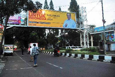 Warga bermain skateboard di bawah reklame Ketua Umum Partai Golkar, Airlangga Hartarto di Bandung, Jawa Barat, 9 Agustus 2021. TEMPO/Prima Mulia