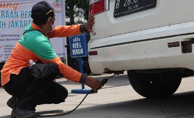 Petugas Dinas Lingkungan Hidup melakukan Uji Emisi kendaraan berbahan bakar bensin di Jalan Perintis Kemerdekaan, Pulogadung, Jakarta, 26 Oktober 2021. TEMPO/ Dwi Nur A. Y