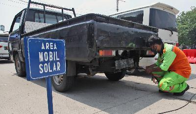 Petugas Dinas Lingkungan Hidup sedang melakukan uji emisi kendaraan berbahan bakar solar di Jalan Perintis Kemerdekaan, Pulogadung, Jakarta, 26 Oktober 2021. TEMPO/ Dwi Nur A. Y
