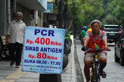 Warga melintas dekat promosi tes usap PCR di Braga, Bandung, Jawa Barat, 1 November 2021. TEMPO/Prima Mulia