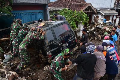 Personel TNI dan warga mengevakuasi mobil yang tersapu banjir bandang di Bulukerto, Kota Batu, Jawa Timur, 5 November 2021. TEMPO/Aris Novia Hidayat