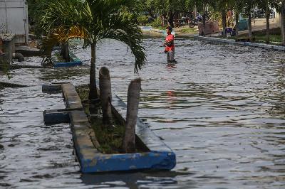 Warga melintasi banjir rob di kawasan Pelabuhan Perikanan Samudera Nizam Zachman, Muara Baru, Jakarta, 6 November 2021. Tempo/Hilman Fathurrahman W