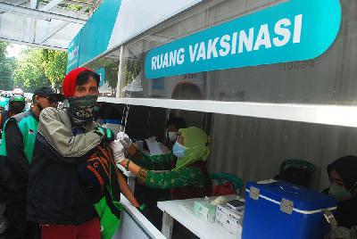 Petugas menyuntik vaksin Covid-19 Sinovac pada warga di lorong sentra vaksin drive thru di Bandung, 9 November 2021. TEMPO/Prima Mulia