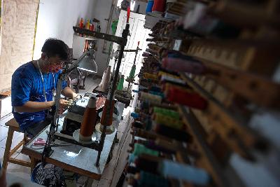 Pekerja menyelesaikan pembuatan baju di butik batik dan tenun  Dewi Sambi di Cipadu, Kota Tangerang, Banten.  Tempo/Tony Hartawan
