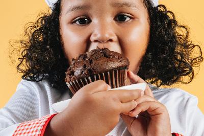 Ilustrasi anak mengonsumsi makanan manis. Pexels/Amina Filkins