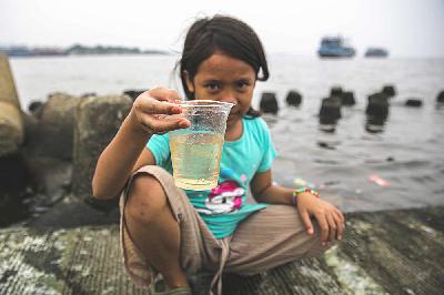 Seorang anak menunjukan air di Kali Adem, Muara Angke, Jakarta, 3 Oktober 2021. TEMPO/Muhammad Hidayat