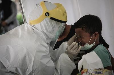 Petugas Kesehatan mengambil sampel usap seorang anak saat mengikuti tes swab PCR di kantor Kecamatan Pancoran Mas, Depok, 5 Januari 2021. TEMPO/M Taufan Rengganis