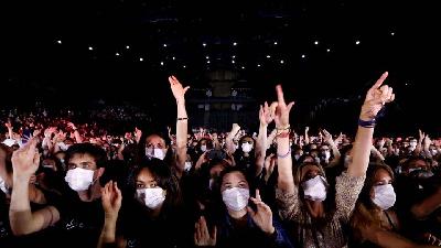 Ilustrasi penonton konser saat pandemi. REUTERS/Christian Hartmann