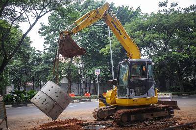 Alat berat membawa material sumur resapan di Jalan Mataram Raya, Kebayoran Baru, Jakarta, 12 Oktober 2021. Tempo/Hilman Fathurrahman W