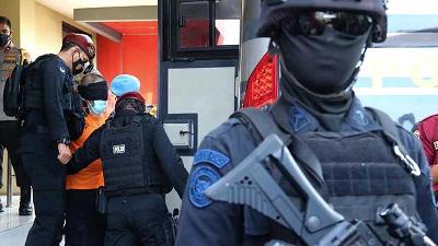 Personel Densus 88 Anti Teror membawa terduga teroris ke dalam bus di Polda Jawa Timur, Surabaya, Jawa Timur, 18 Maret 2021. ANTARA/Didik Suhartono