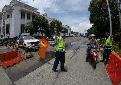Petugas menutup jalan menuju kawasan Kota Tua saat uji coba penerapan kebijakan kawasan rendah emisi di Kota Tua, Jakarta, 8 Februari 2021. TEMPO/Subekti