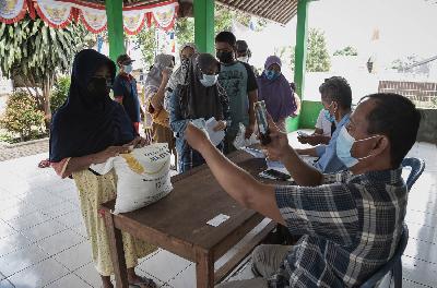Warga antre mendapatkan bantuan beras bansos di Sukatani, Tapos, Depok, Jawa Barat, 19 Agustus 2021. TEMPO/M Taufan Rengganis